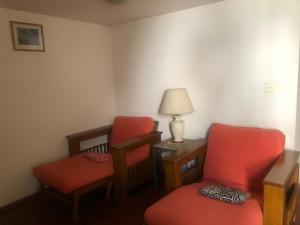 Habitación con 2 sillas y mesa con lámpara. en Corazón de Mendoza en Mendoza