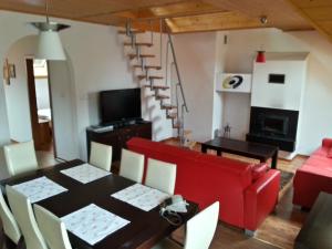 sala de estar con mesa y sofá rojo en Belweder Apartamenty i Pokoje, en Wisła