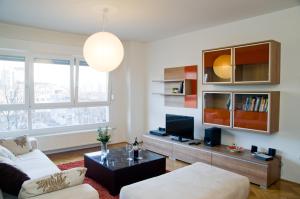 uma sala de estar com um sofá e uma televisão em Apartment Adagio em Zagreb