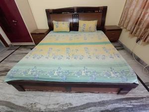 a bedroom with a large bed with a blue comforter at OYO HOME Satvik Homestay in Ayodhya