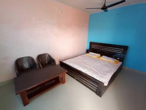 a small bedroom with a bed and a chair at OYO HOME Satvik Homestay in Ayodhya