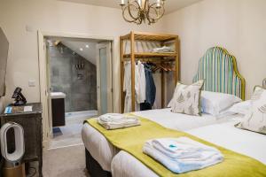 2 łóżka w pokoju z umywalką i lustrem w obiekcie The Pheasant w mieście Helmsley