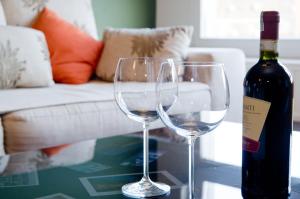 dois copos de vinho sentados numa mesa com uma garrafa de vinho em Apartment Adagio em Zagreb