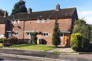 a brown brick house with a black roof at Double Room, Large TV, With Great Transport Links in Bolton