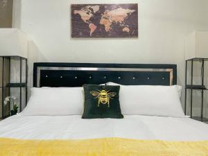 a bed with a pillow with a bee on it at Bee our Guest! SLC Cozy Beehive in Salt Lake City