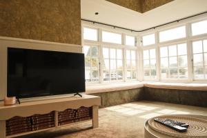 a large living room with a large flat screen tv at Victorian Designs - Spacious Home in Rotorua Central in Rotorua