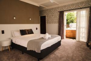 a bedroom with a large bed and a large window at Victorian Designs - Spacious Home in Rotorua Central in Rotorua