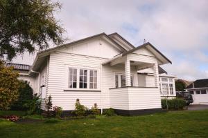 a white house with a gambrel at Victorian Designs - Spacious Home in Rotorua Central in Rotorua