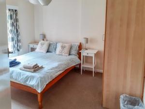 a small bedroom with a bed and a table at Green Hedges in Budleigh Salterton