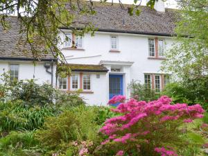 a white house with pink flowers in front of it at Green Hedges in Budleigh Salterton