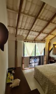 Schlafzimmer mit einem Bett, einem Tisch und einem Fenster in der Unterkunft Chiibal in Tulum