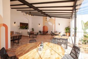 a room with a wooden table and chairs and tables at Hotel Rural el Turuñuelo 