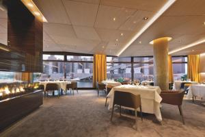 a restaurant with white tables and chairs and windows at The Ritz-Carlton, Wolfsburg in Wolfsburg