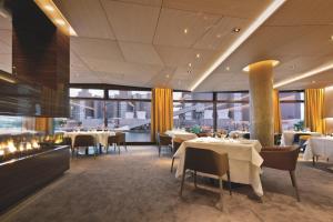 ein Restaurant mit weißen Tischen, Stühlen und Fenstern in der Unterkunft The Ritz-Carlton, Wolfsburg in Wolfsburg