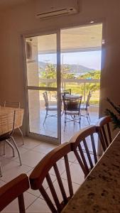 a room with a balcony with a table and chairs at Reserva Dell Mar in Bertioga