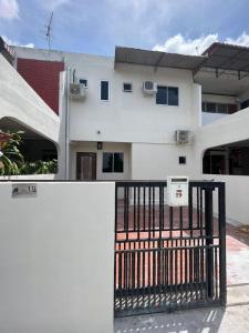Uma casa branca com um portão à frente. em Homestay Suria em Kuala Kangsar