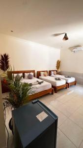 Habitación con 2 camas y mesa. en Hakuna Matata Resort Gili Air, en Gili Air