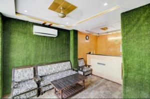 a waiting room with a bench and green walls at OYO 81146 Hotel Prashant Villa in Gwalior