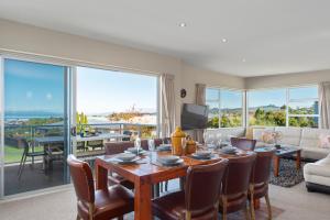 a living room with a table and chairs and a large window at The Lakehouse - Taupo in Taupo