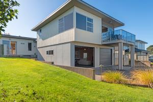 a house on a hill with a green yard at The Lakehouse - Taupo in Taupo