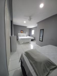 a large bedroom with two beds and a window at Recanto Familiar in Monte das Gameleiras