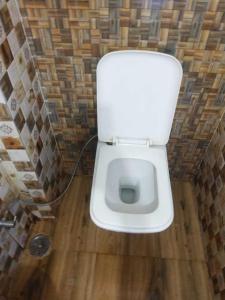 a bathroom with a white toilet in a room at OYO 81095 Hotel Nathdwara in Nāthdwāra