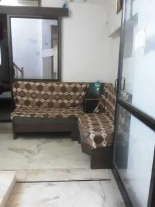 a couch sitting in a room with a mirror at OYO 81095 Hotel Nathdwara in Nāthdwāra
