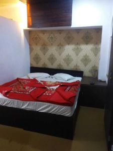 a bed in a room with a red blanket on it at OYO 81095 Hotel Nathdwara in Nāthdwāra