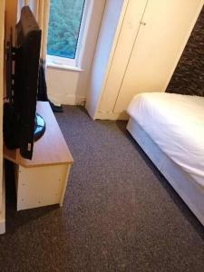 1 dormitorio con 1 cama y TV en una mesa en Home of maximum relaxation/rest en Gillingham
