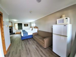 a room with a couch and a bed with a microwave at Knights Inn Colonial Fireside Inn in Pembroke