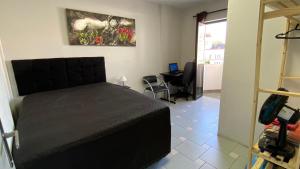 a bedroom with a bed and a table with a laptop at Apart 2 dorm. Prox Cambuí Wi-Fi Gar Var Note Pet in Campinas