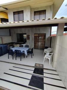 un patio con mesa y sillas en un edificio en Casa Beira-mar - Praia do Flamengo - Salvador - Bahia, en Salvador