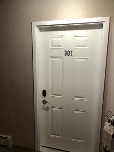 Una puerta blanca con el número. en unit #301 Mountain view 1BR in Canmore Down town, en Canmore