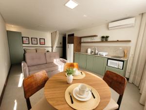 cocina y comedor con mesa y sillas en Residence Farol - Loft 204, en Laguna