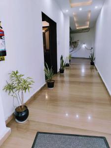 an empty hallway with potted plants in a building at OYO RU Hotel And Banquet Hall in Rewāri