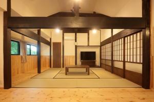 una sala de estar con un banco en el centro en 【コテージくぎの】大谷川沿いの露天風呂があるコテージ, en Minami Aso