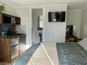 a bedroom with a bed and a tv on the wall at Studio 16 in Kyneton