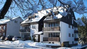 a white house with snow on the roof at Welcome in - Studio met balkon, dichtbij skipiste in Winterberg in Winterberg