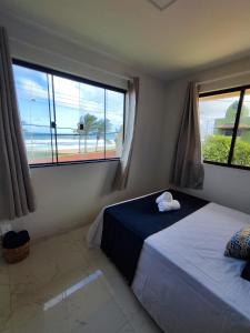 1 dormitorio con 2 camas y vistas al océano en Casa Beira-mar - Praia do Flamengo - Salvador - Bahia, en Salvador