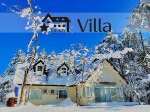 a house covered in snow with trees at Meteor Garden in Hakuba
