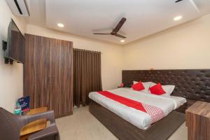 - une chambre avec un grand lit et des oreillers rouges dans l'établissement OYO Flagship ELEGANT RESIDENCY, à Chennai