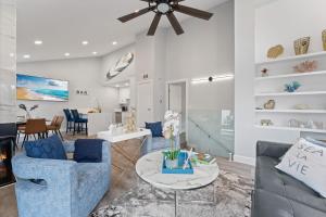 una sala de estar con sofás azules y una mesa. en Searenity Suite- Peekaboo Ocean view 1 min walk to Beach en Huntington Beach