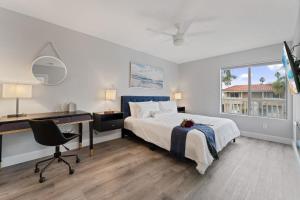 a bedroom with a bed and a desk and a computer at Searenity Suite- Peekaboo Ocean view 1 min walk to Beach in Huntington Beach