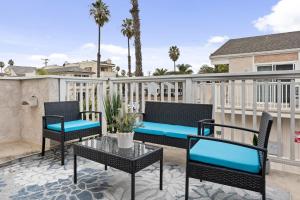 um pátio com cadeiras e um banco numa varanda em Searenity Suite- Peekaboo Ocean view 1 min walk to Beach em Huntington Beach