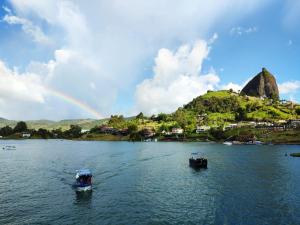 zwei Boote im Wasser mit Regenbogen im Hintergrund in der Unterkunft Apartamento con vista al embalse in Guatapé