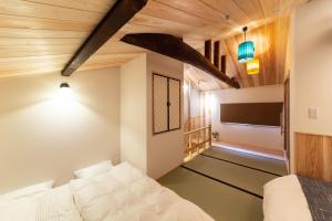 1 dormitorio con 1 cama y TV de pantalla plana en Kuraki-an, en Kioto
