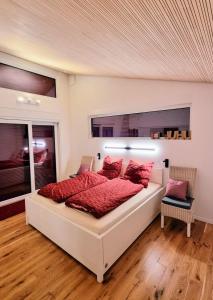 1 dormitorio con 1 cama grande con almohadas rojas en Exklusives Holzhaus mit Bergbahn - Baden-Baden im Schwarzwald, en Baden-Baden