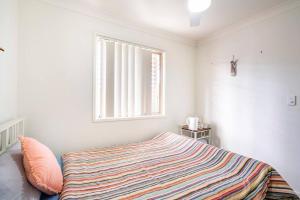 a bedroom with a bed with a striped blanket at Private Room with Separate Bath in Shared Accommodation with Private Access in Redcliffe +38 photos