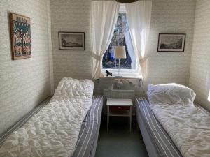 1 dormitorio con 2 camas, escritorio y ventana en Holiday home Vingåker III, en Vingåker