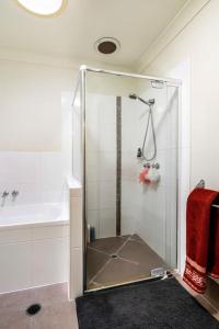 y baño con ducha y puerta de cristal. en Private Room with Separate Bath in Shared Accommodation, en Redcliffe